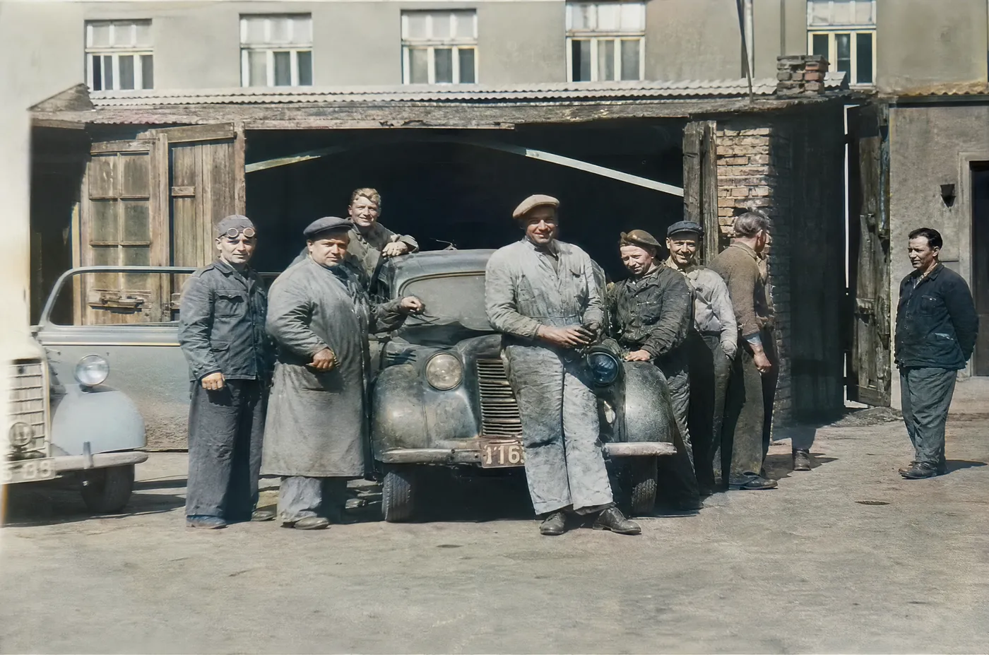 Archiwalne zdjęcie ekipy warsztatu przed bramą warsztatu